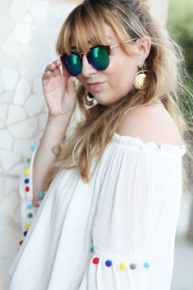 What to wear in Barcelona: pom pom off the shoulder top and major earrings.