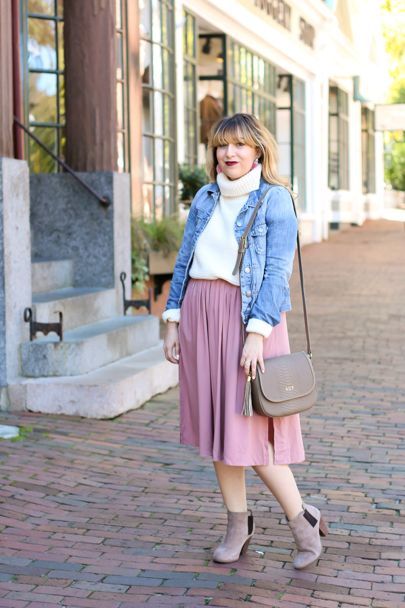 Miami fashion blogger Stephanie Pernas styles a pink midi skirt with a turtleneck sweater and jean jacket for a cute fall outfit idea.