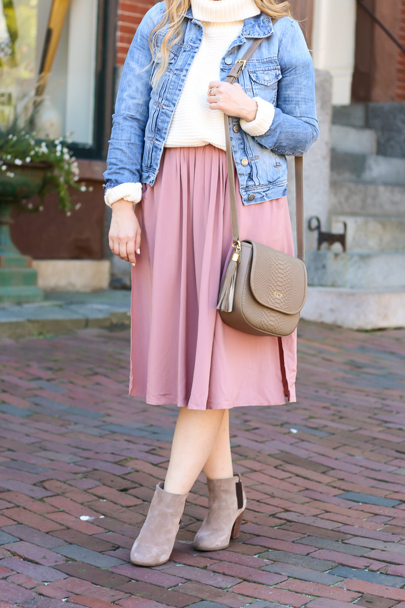 Miami fashion blogger Stephanie Pernas styles light fall layers by pairing a midi skirt with a turtleneck sweater and jean jacket.