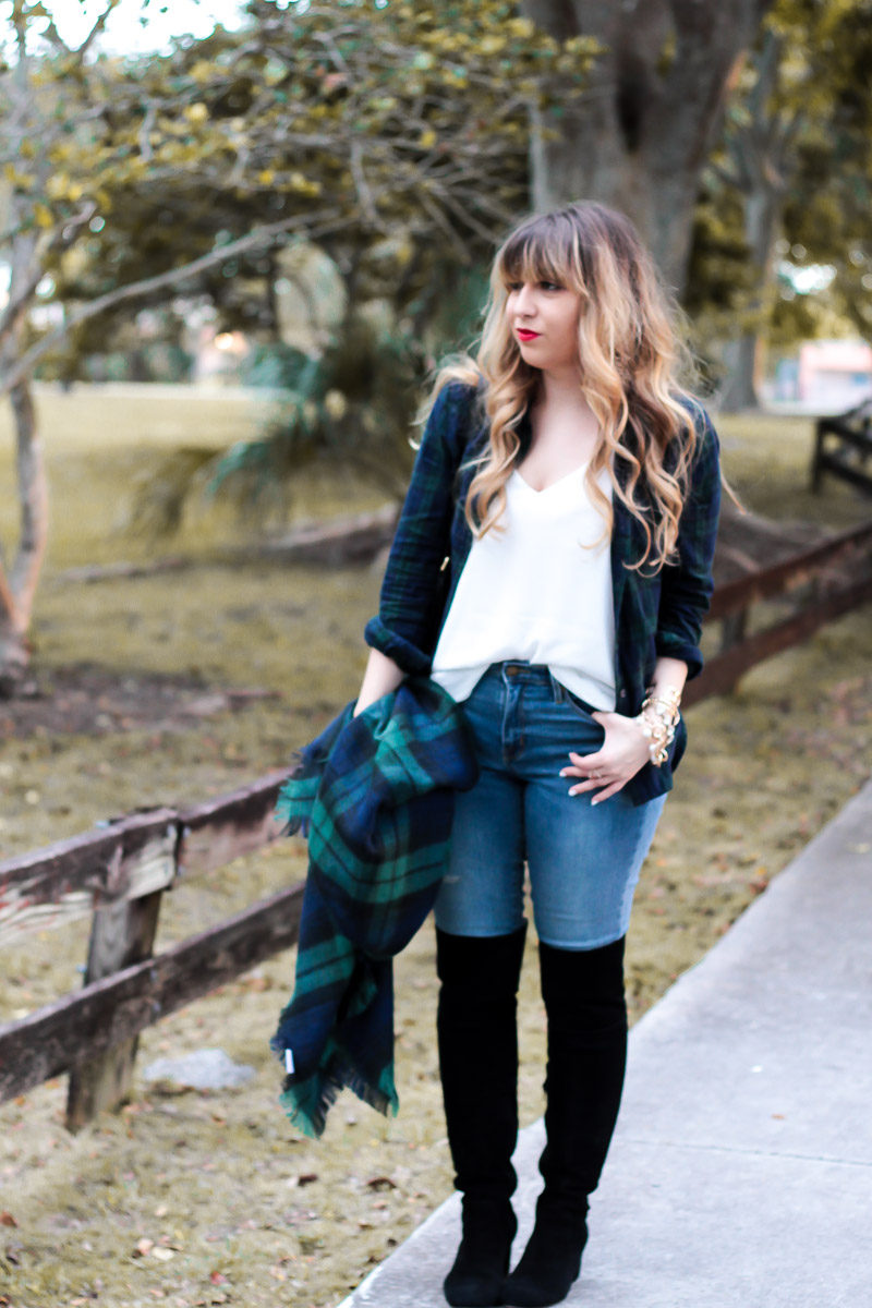 Miami fashion blogger Stephanie Pernas styles a black watch plaid blanket scarf and top with jeans and over the knee boots for a cute casual holiday plaid shirt outfit