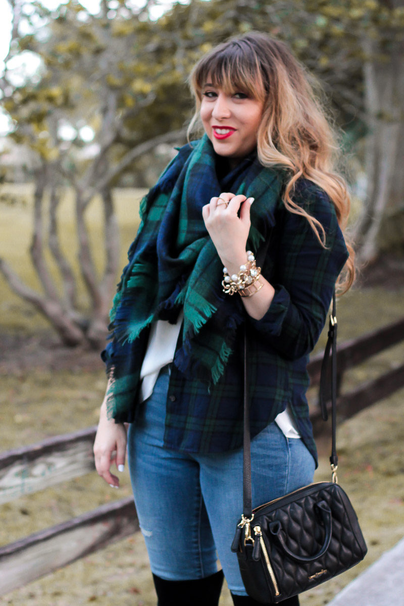 Miami fashion blogger Stephanie Pernas styles a black watch plaid blanket scarf with a coordinating button down for a chic and easy casual holiday outfit