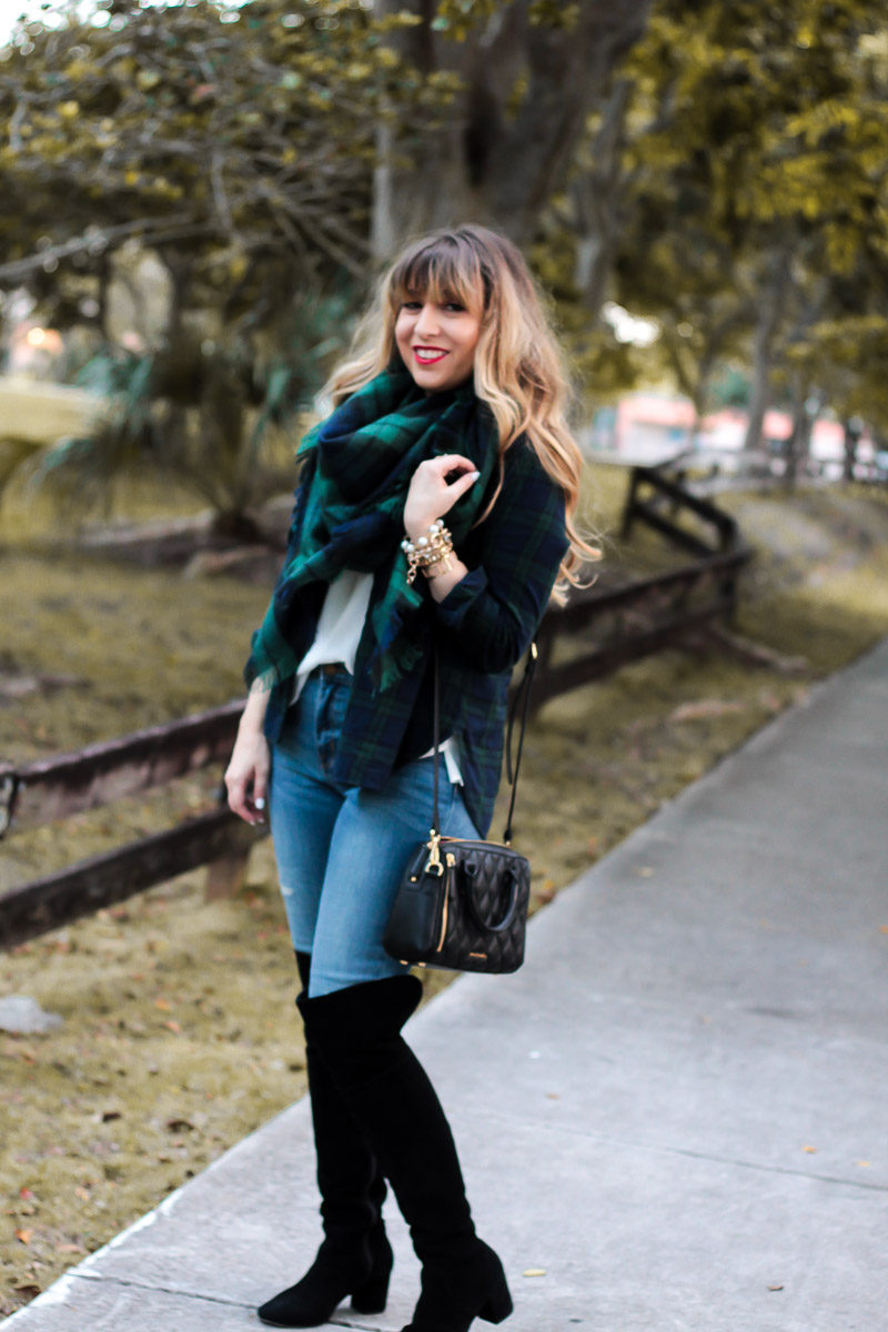 Fashion blogger Stephanie Pernas wears black over the knee boots and a black watch plaid scarf and button down 