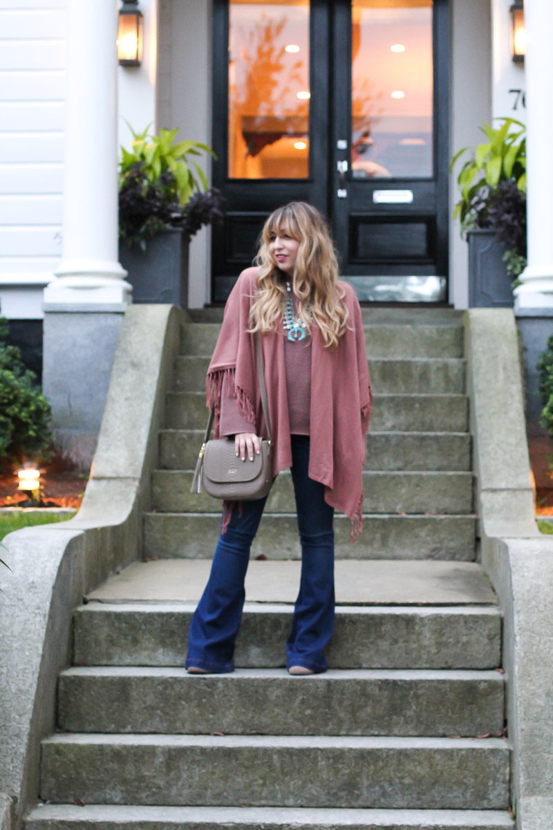 Miami fashion blogger Stephanie Pernas wears flare jeans, a fringe poncho and a bell sleeve sweater