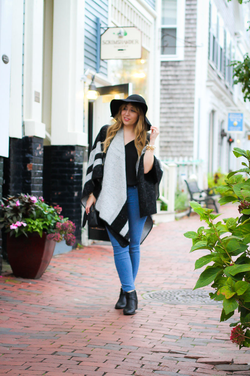 Miami fashion blogger Stephanie Pernas styles an easy fall outfit: stripe poncho, jeans, and booties.