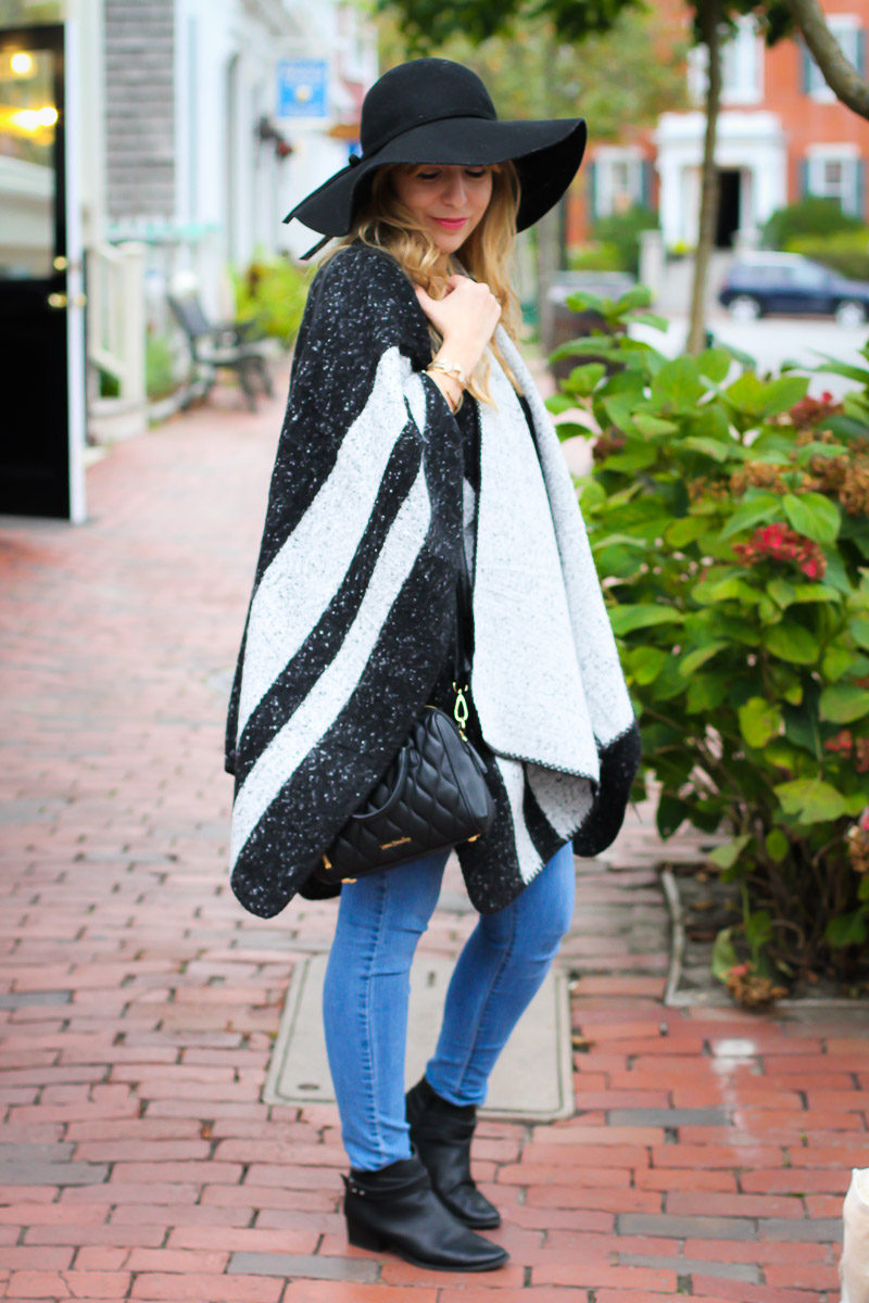 Miami fashion blogger Stephanie Pernas styles a cozy cape with jeans and booties for an easy fall outfit idea. 