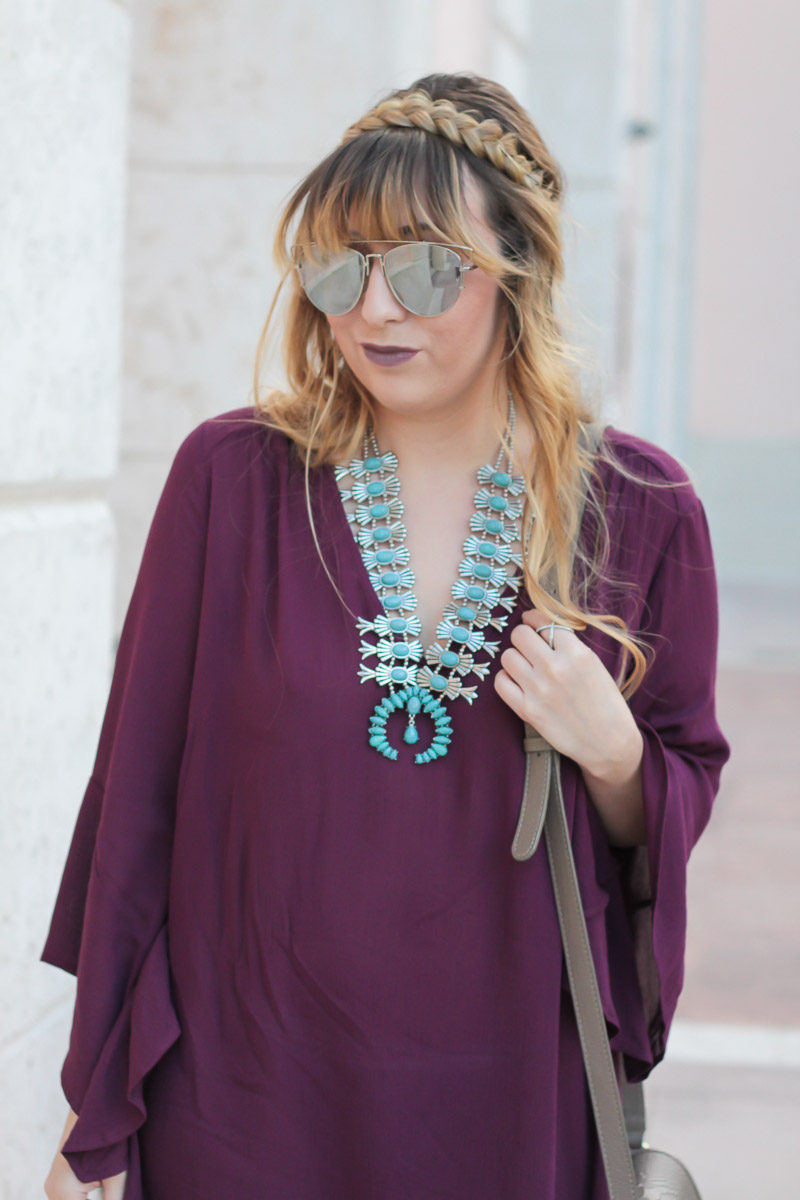 Fashion blogger Stephanie Pernas wearing a plum bell sleeve dress and braided hairstyle