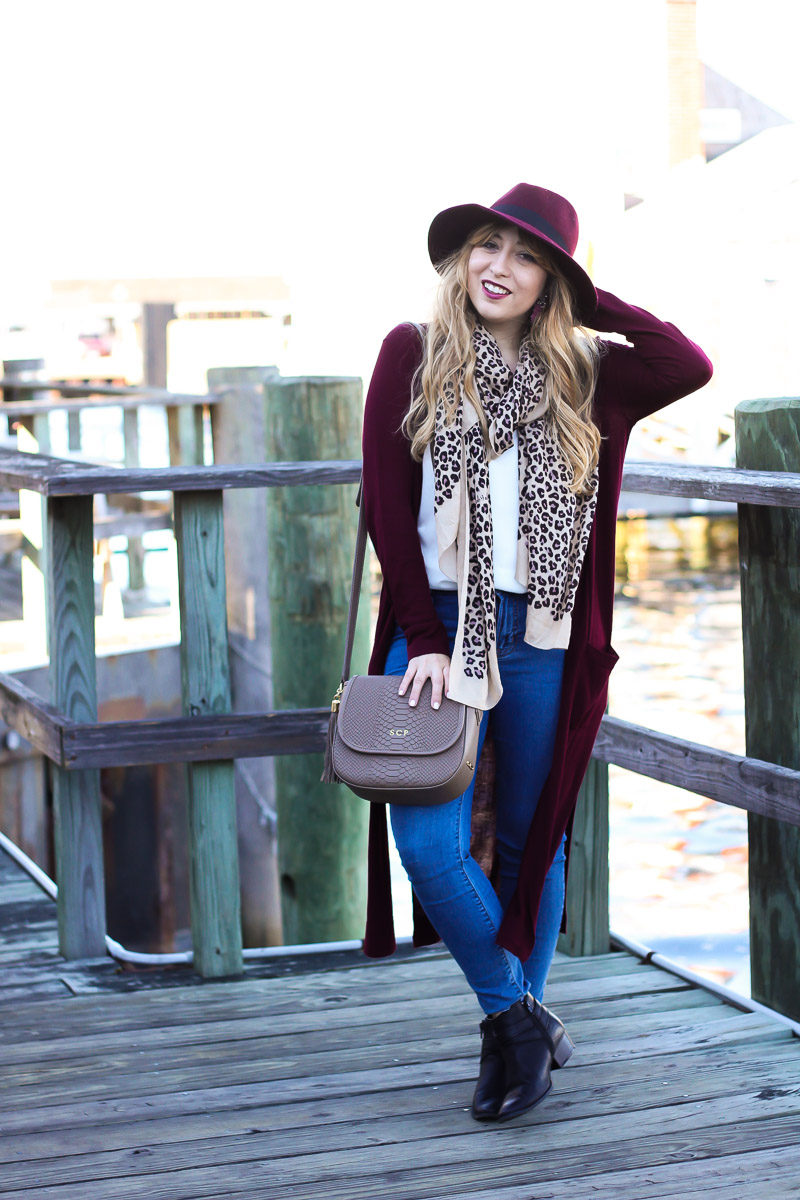 Miami fashion blogger styles a long wine colored cardigan with jeans, booties and a leopard scarf for a cool fall outfit