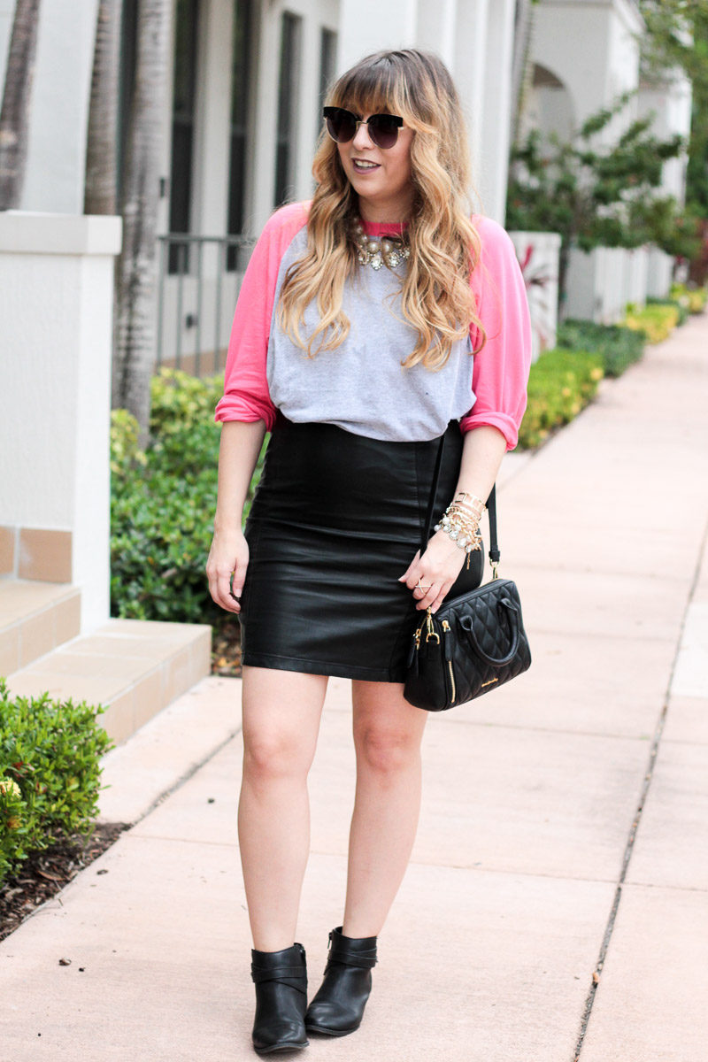 Miami fashion blogger Stephanie Pernas styling a cute baseball tee with a leather mini skirt and booties