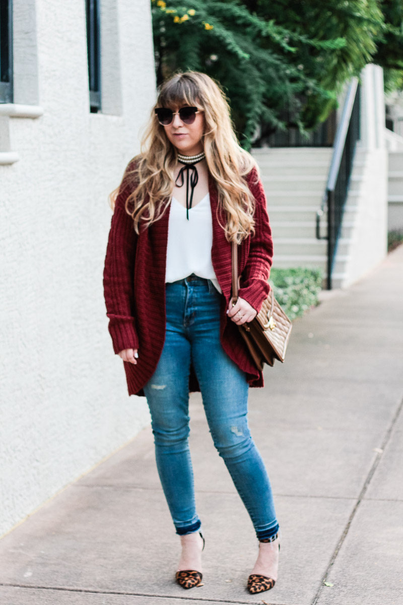 Miami fashion blogger Stephanie Pernas of A Sparkle Factor styles a burgundy cardigan with jeans and leopard pumps for a casual fall outfit idea 