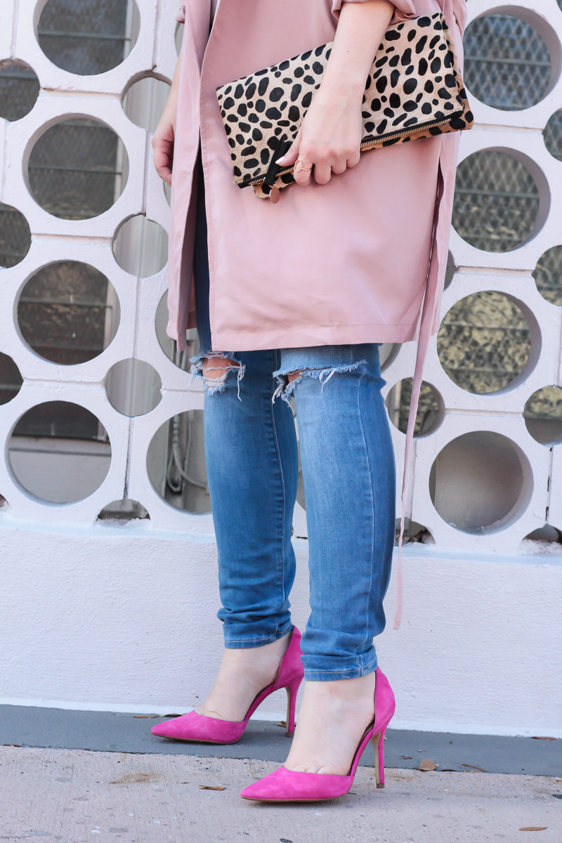 Miami fashion blogger Stephanie Pernas of A Sparkle Factor styles a cute trench coat outfit idea by pairing a pink trench coat with skinny jeans and bold pumps 