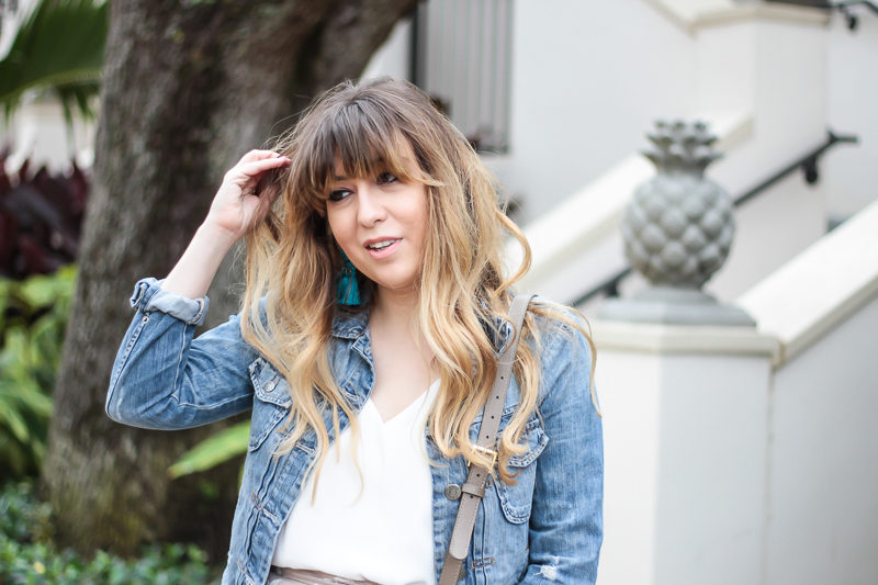 Miami fashion blogger Stephanie Pernas wearing a jean jacket and tassel earrings 