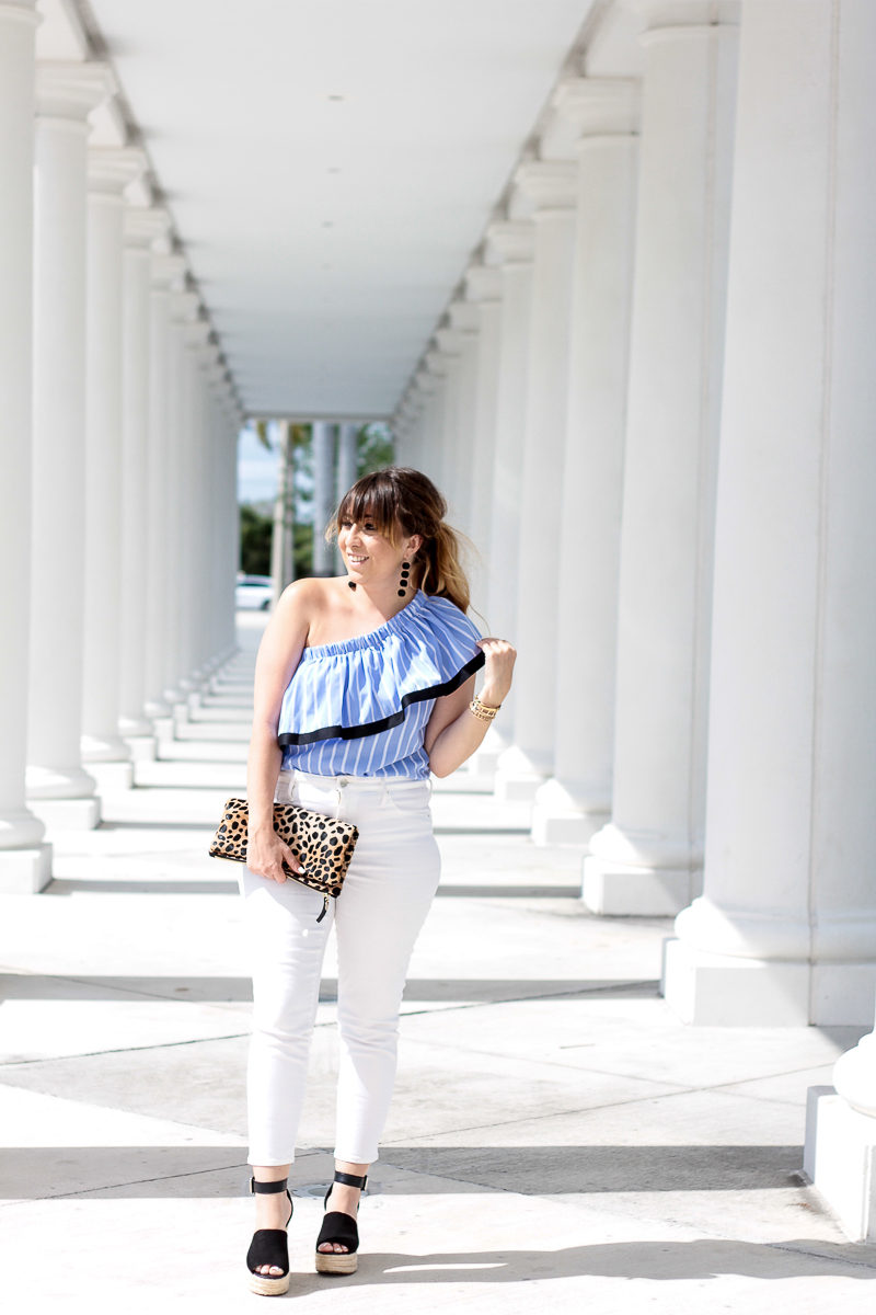 Miami fashion blogger Stephanie Pernas wearing a blue one shoulder ruffle top and white jeans 