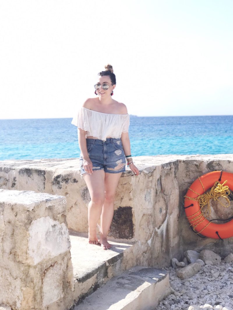 Miami fashion blogger Stephanie Pernas wearing an off the shoulder crop top and jean shorts outfit