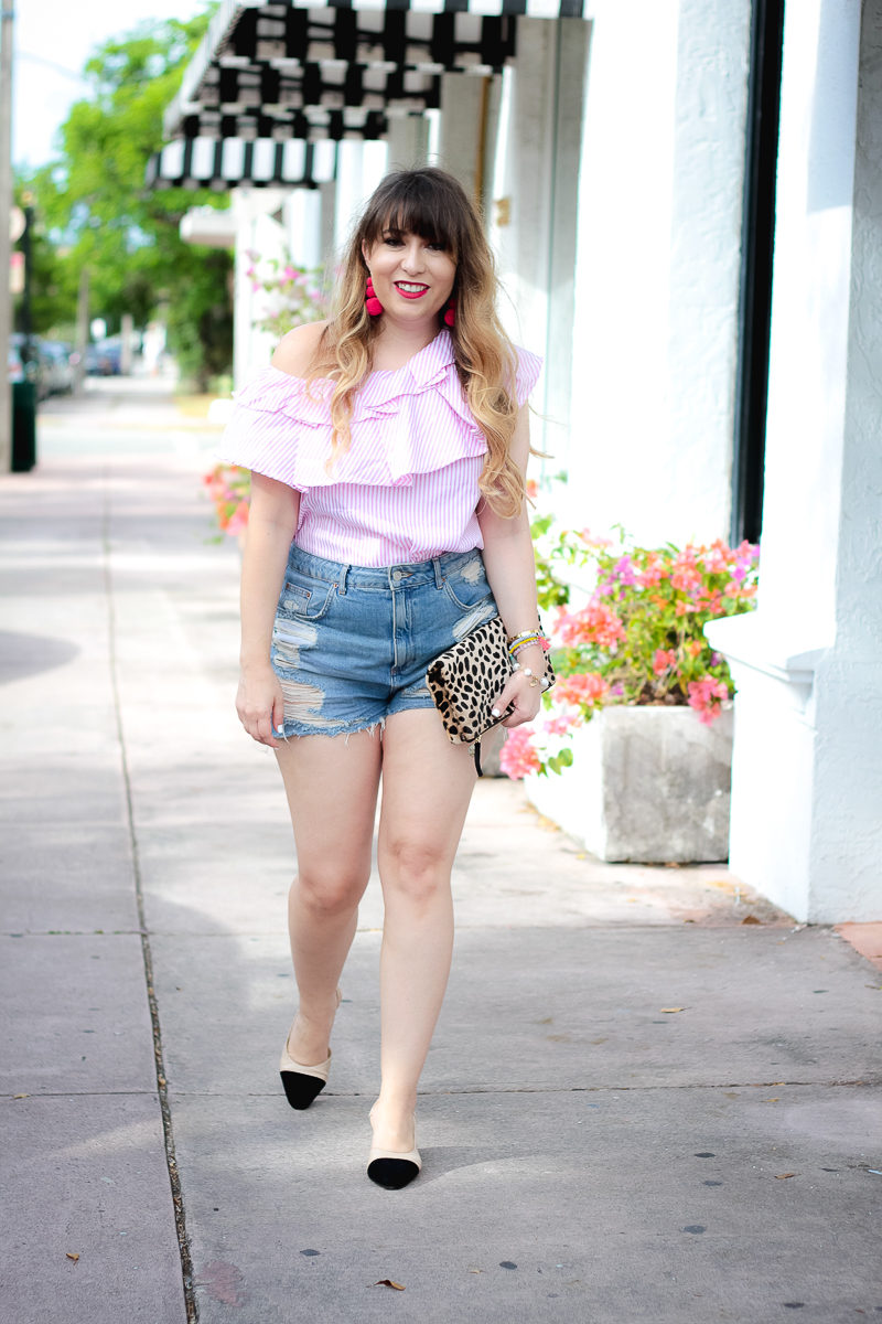 Miami fashion blogger Stephanie Pernas wearing high waisted jean shorts and a one shoulder ruffle top for summer 