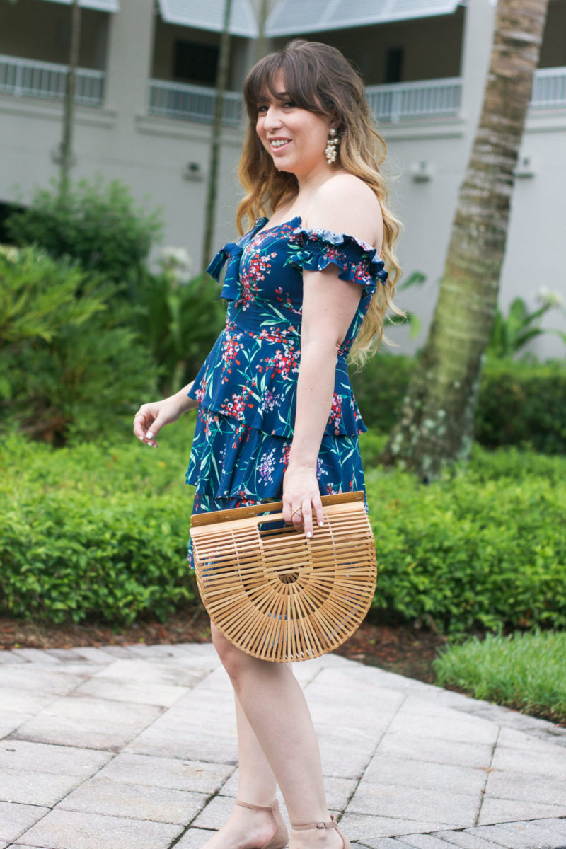 Fashion blogger Stephanie Pernas wearing a floral dress and bamboo bag